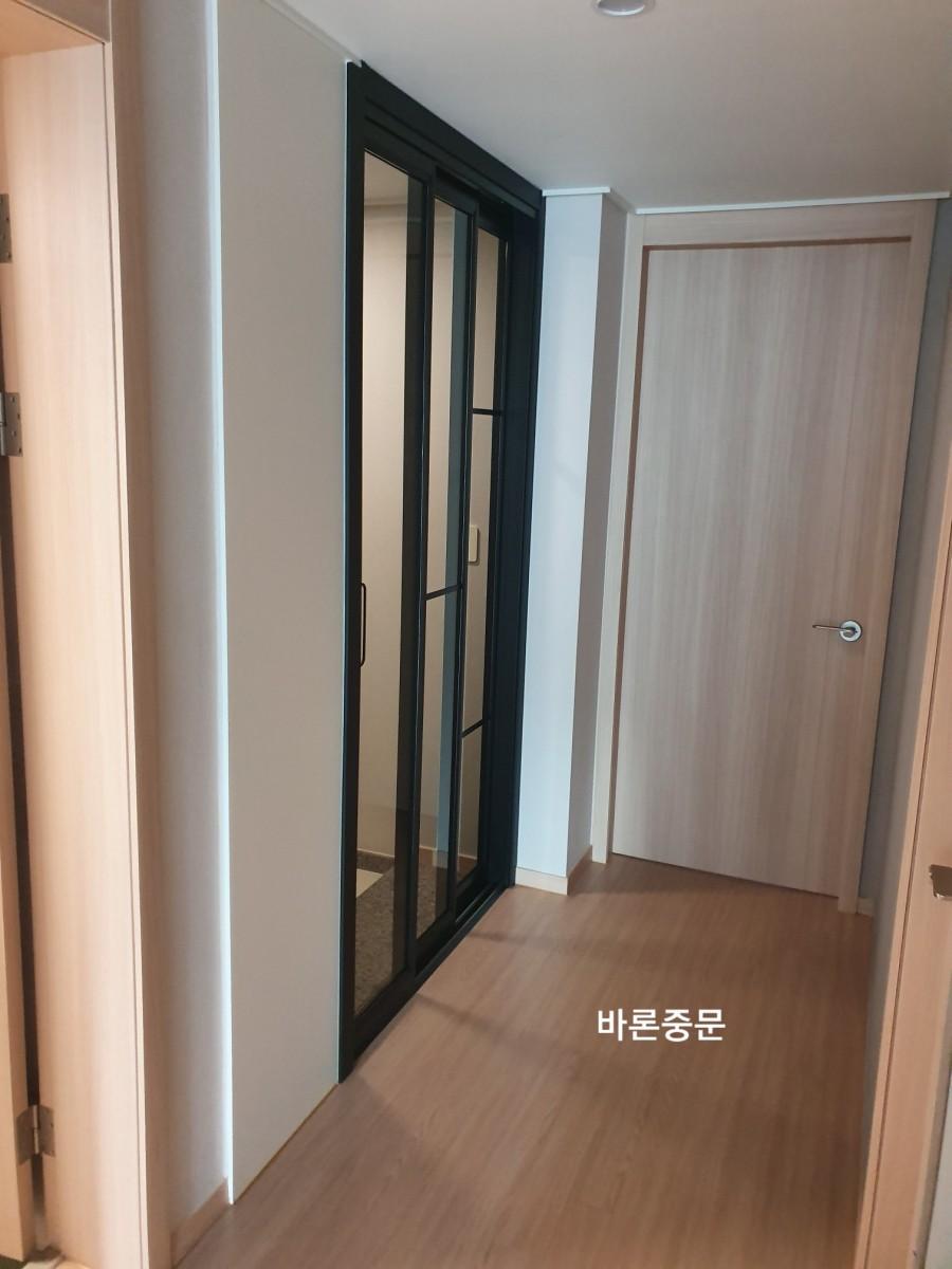 흰 벽면과 목재 바닥이 어우러진 복도 전경
