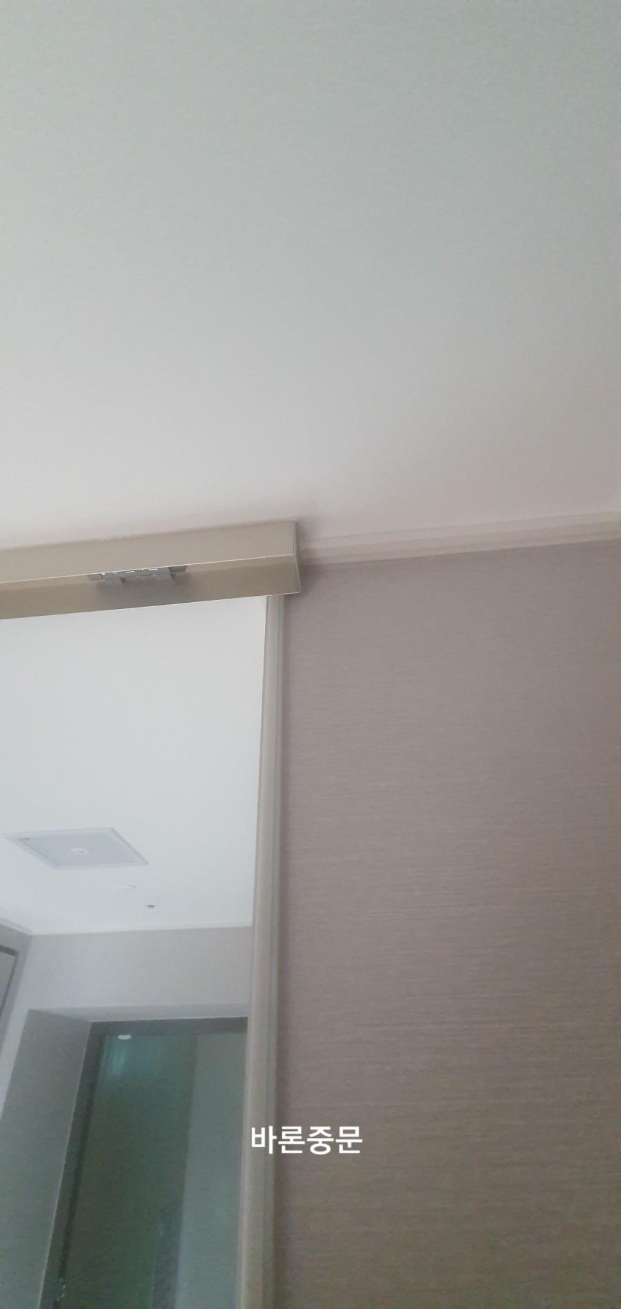 벽지 마감면과 맞닿은 문 상단 금속 프레임