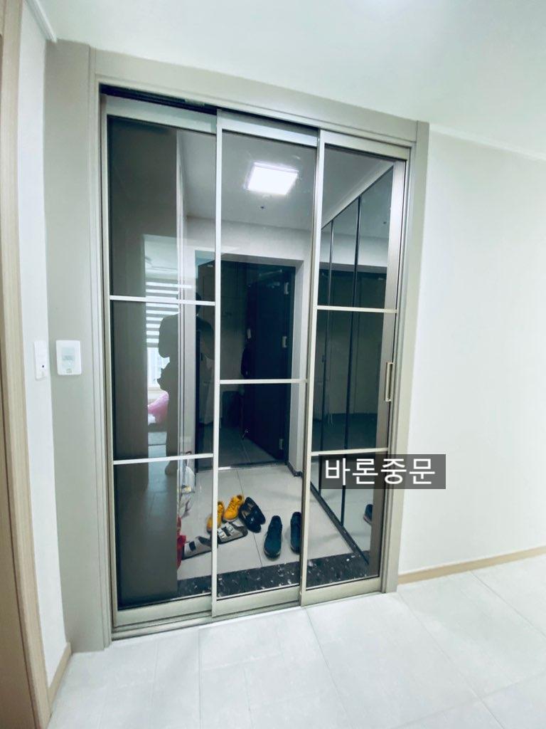 현관 안쪽에서 바라본 슬라이딩 도어와 흰색 타일 바닥