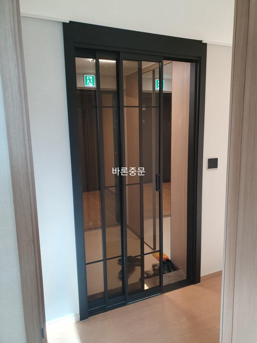 복도에서 바라본 블랙 프레임 중문의 모습