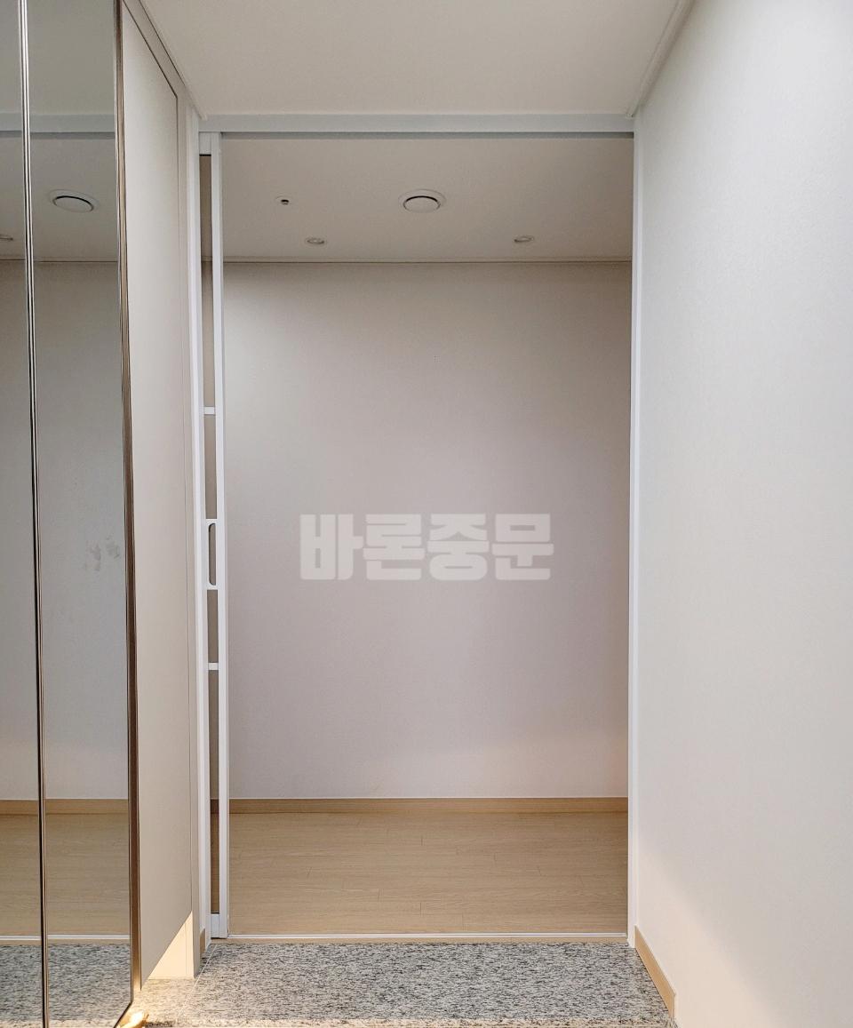 흰 벽과 목재 바닥이 펼쳐진 복도 전경