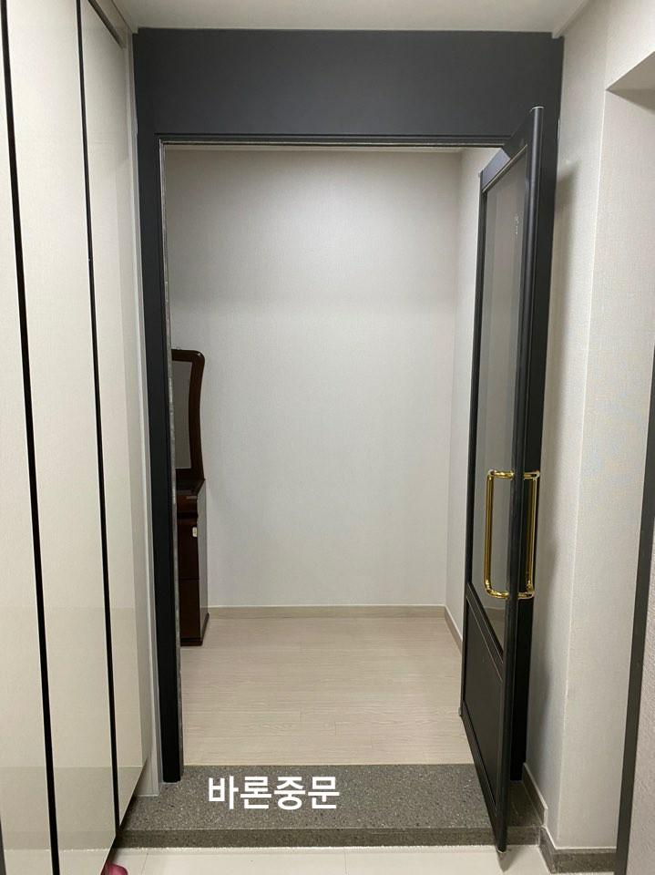 현관 바닥재와 블랙 도어가 맞닿은 모습