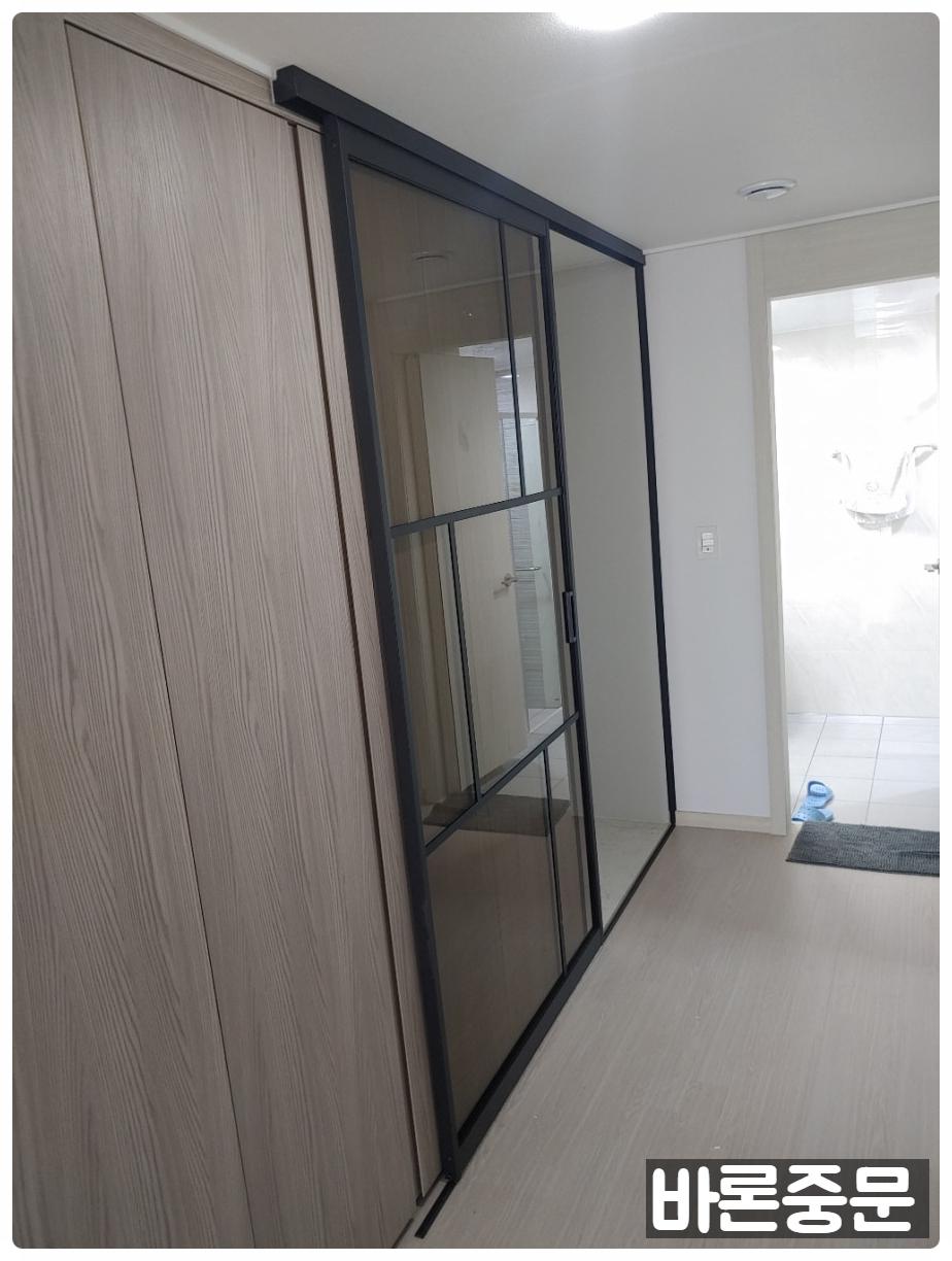 목재 패널 벽면과 연결된 슬라이딩 도어의 전체적인 모습