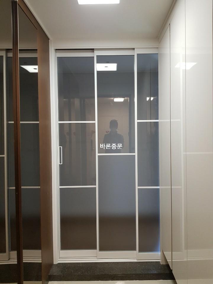 흰색 프레임의 슬라이딩 도어가 설치 중인 모습