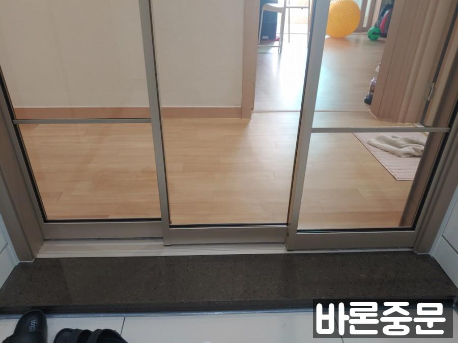 목재 바닥 위로 설치된 샴페인 골드 중문