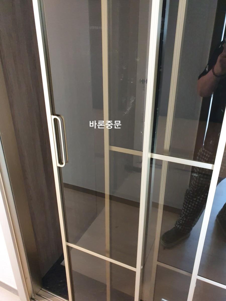 매끄럽게 마감된 유리문과 목재 패널의 접합부