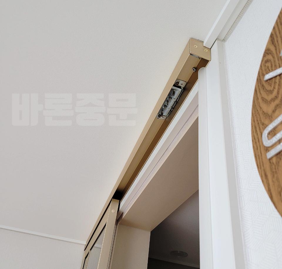벽면과 연결된 금속 재질의 도어 조절 장치