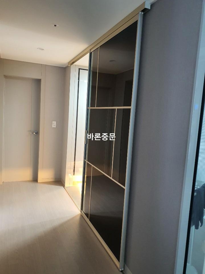 베이지색 바닥과 흰색 벽면에 설치된 슬라이딩 도어 프레임