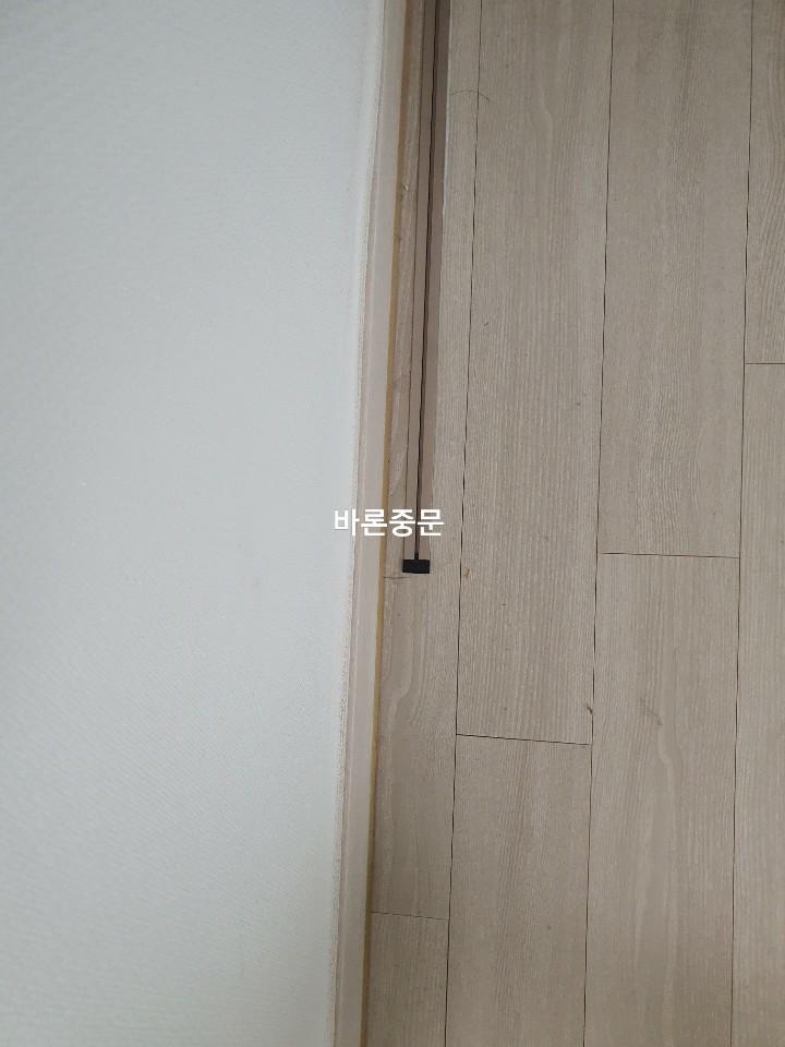 바닥재 틈새에 설치된 검은색 부품 디테일