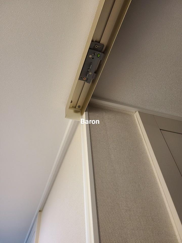 문 상단의 금속 레일과 고정 장치 근접 샷