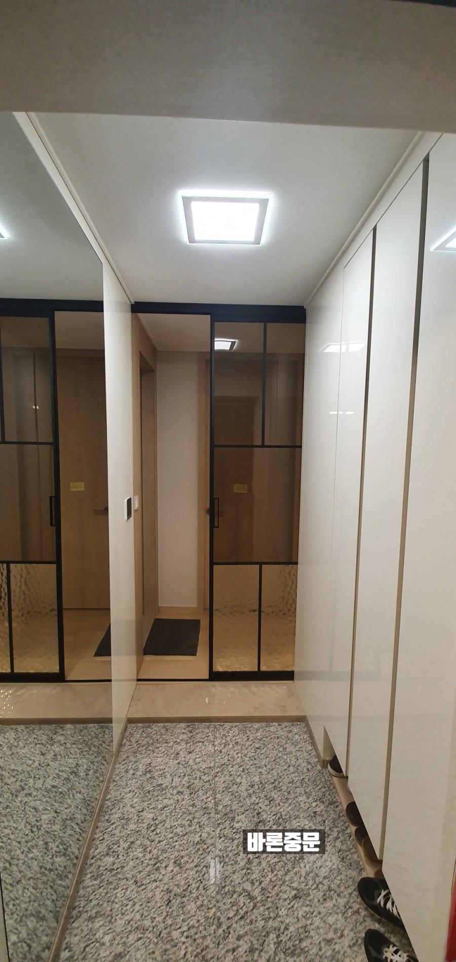 화이트 수납장 옆에 배치된 유리 도어