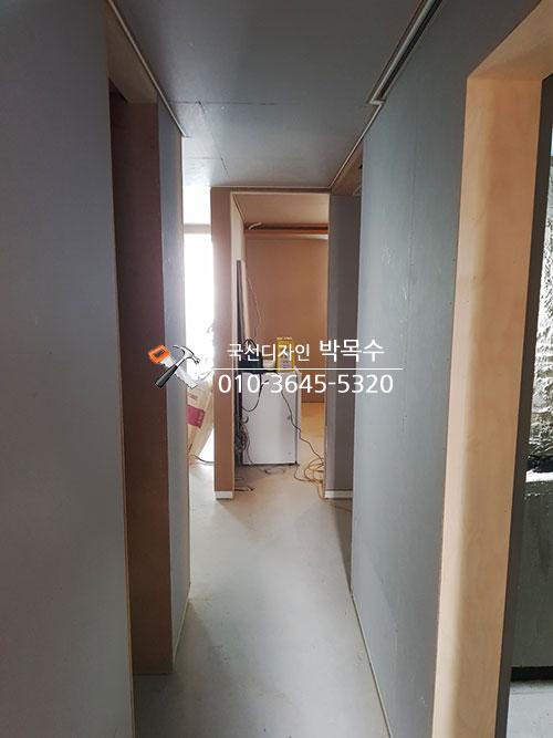회색 천장과 베이지색 벽면이 만나는 복도