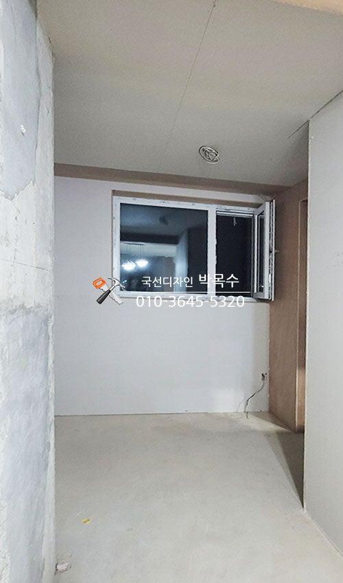 전선이 노출된 흰 벽과 천장의 빈 방 모습