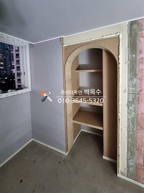 흰색 테두리로 마감된 아치형 수납장 입구
