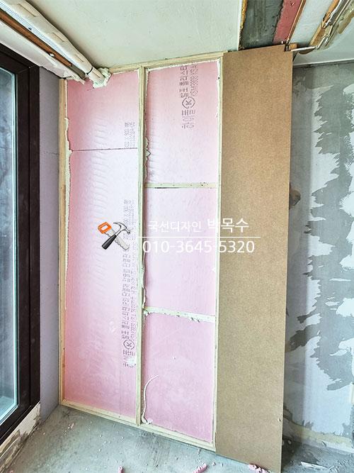 핑크색 단열재와 베이스보드가 설치된 벽면