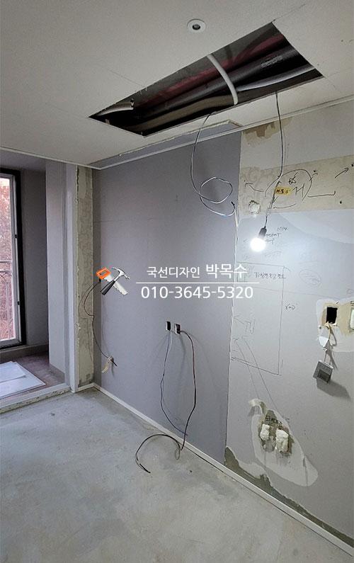 천장이 개방되어 전선이 노출된 실내 벽면