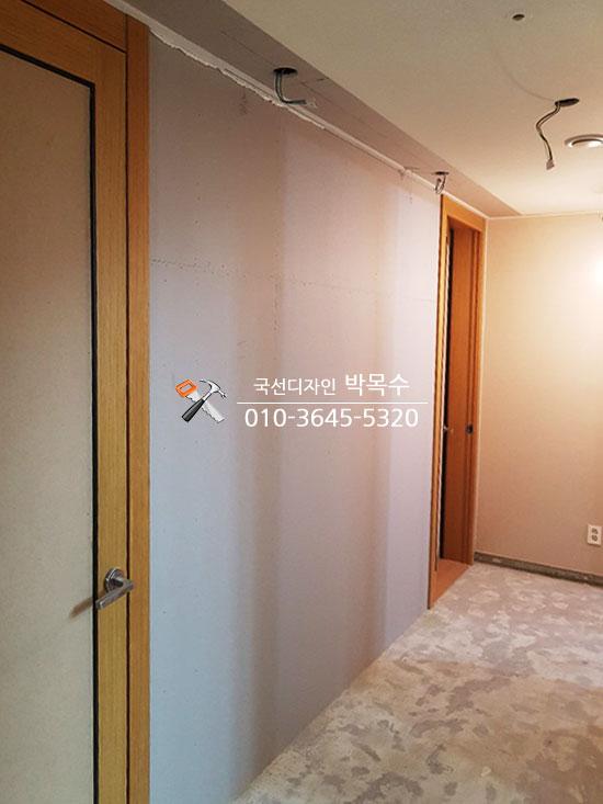 화이트 톤의 벽면과 나무 도어가 맞닿은 실내 모습