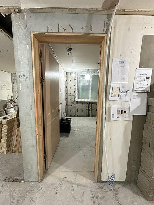 깔끔한 문틀 마감으로 완성되어가는 복도 공간
