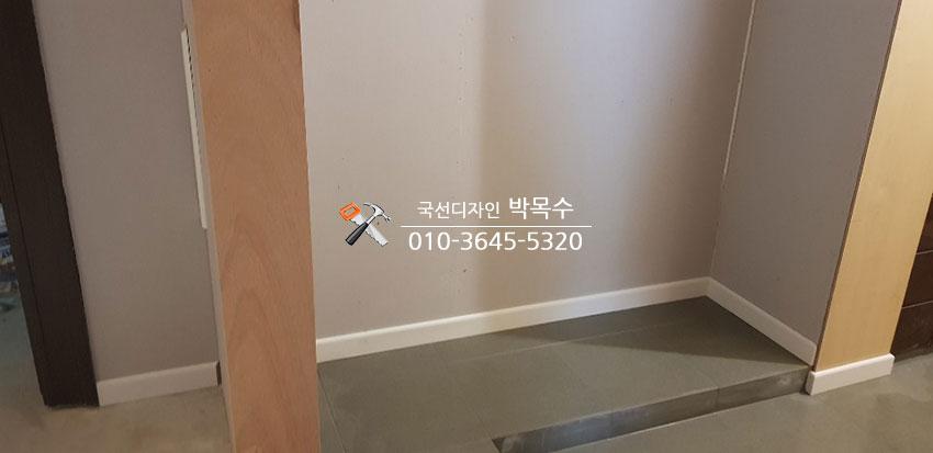 회색 벽과 흰색 베이스보드, 회색 타일 바닥의 복도