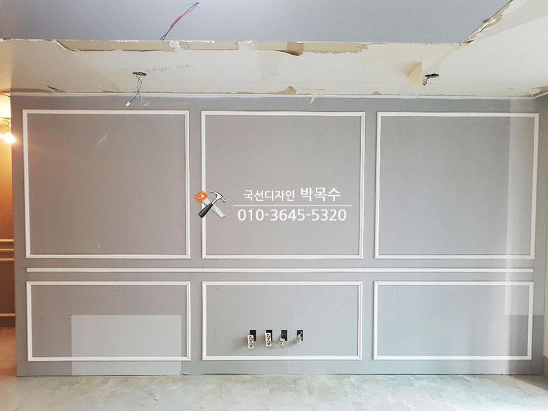 흰색 프레임이 설치된 공사 중인 벽면