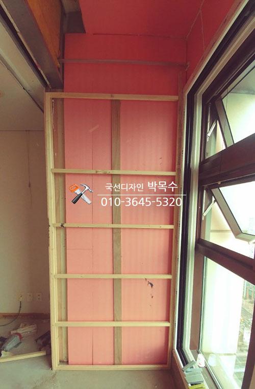 나무 프레임과 분홍색 벽면이 맞닿은 목공 기초 단계