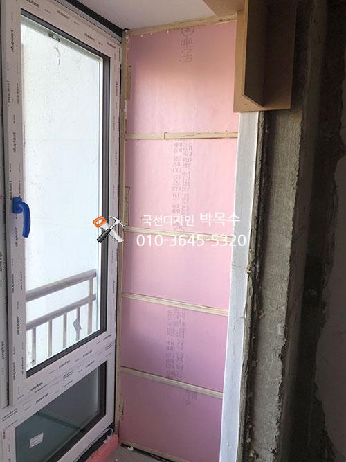 창호 주변에 분홍색 보온재를 채워 넣는 모습