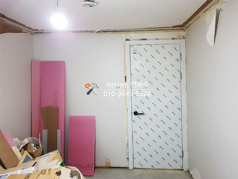 분홍색 보드와 자재들이 배치된 벽면 골조 작업