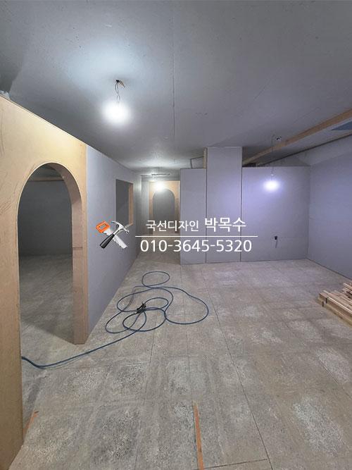 흰색 벽면 마감과 아치형 문틀이 들어선 복도 모습