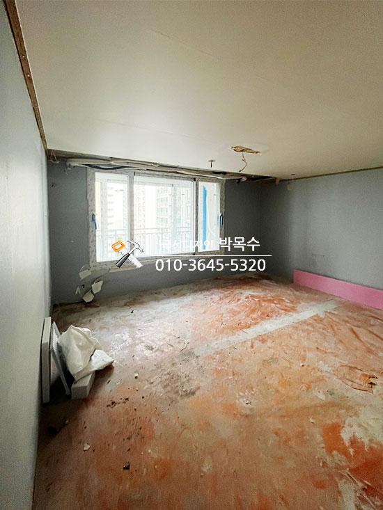 회색 벽면과 흙색 바닥재가 덮인 작업 현장