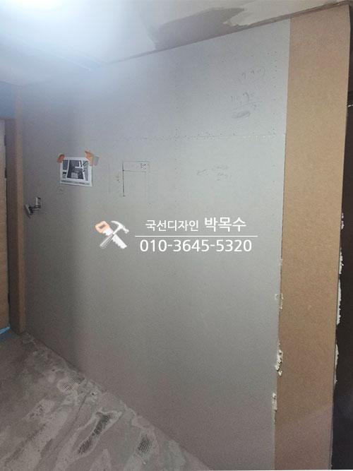 흰색 페인트로 마감된 복도 벽면과 도어 설치 준비