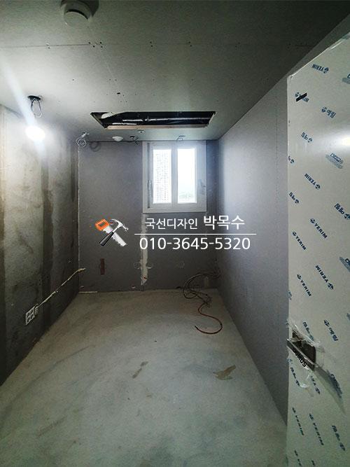 회색 벽면과 흰색 보드 구조물이 있는 공간