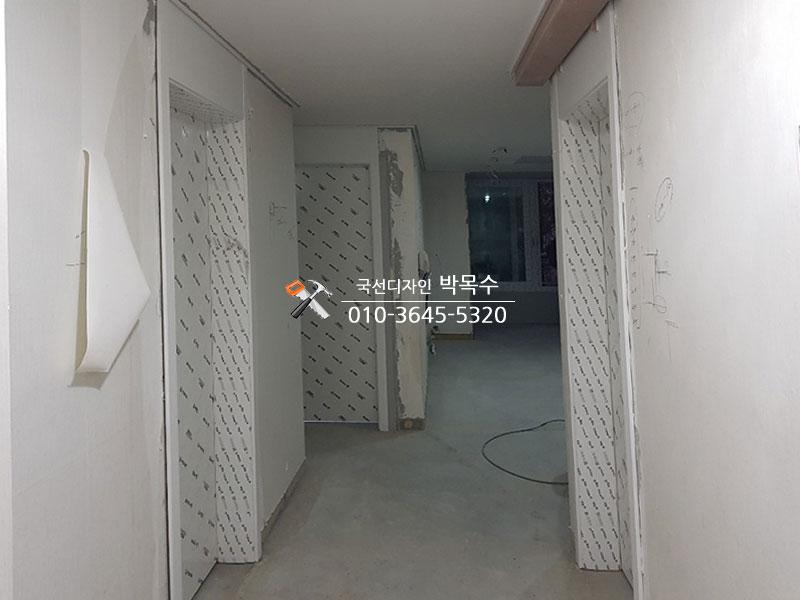 보조 구조물이 설치된 복도 벽면과 콘크리트 바닥