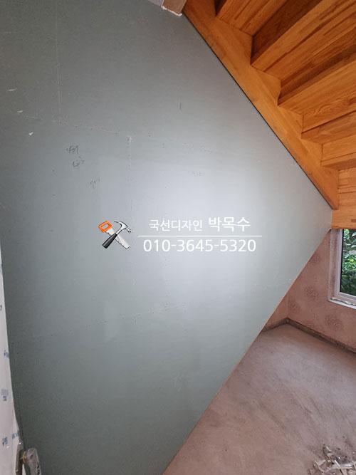 나무 구조 천장과 회색 벽면이 보이는 실내