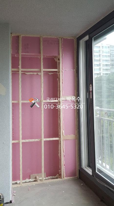 핑크색 보조재와 목재 프레임으로 벽면 단열을 진행하는 과정