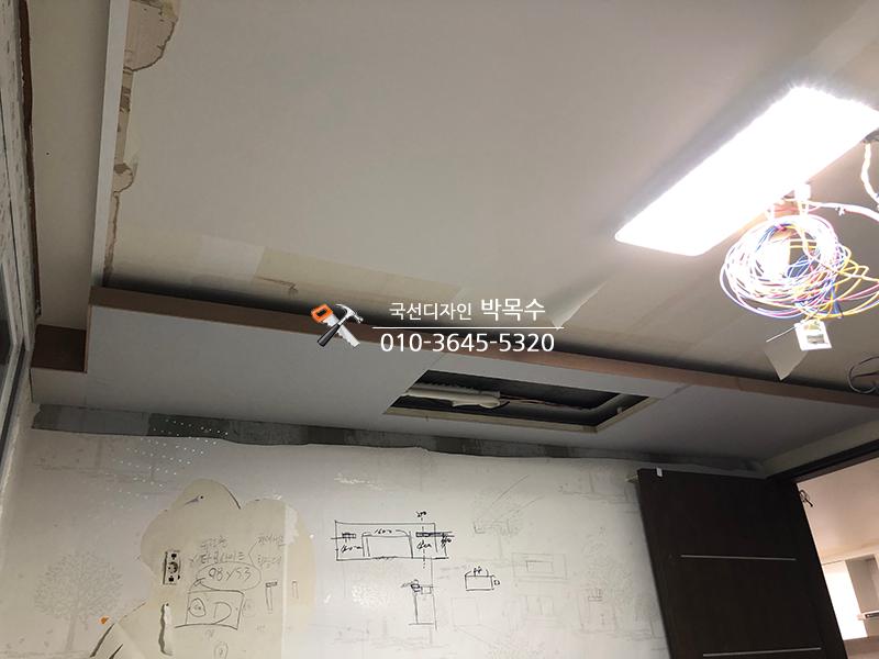 설계도가 부착된 벽면과 노출된 천장 전선