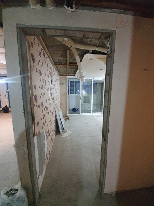 배관이 노출된 천장과 부분 도배된 벽면