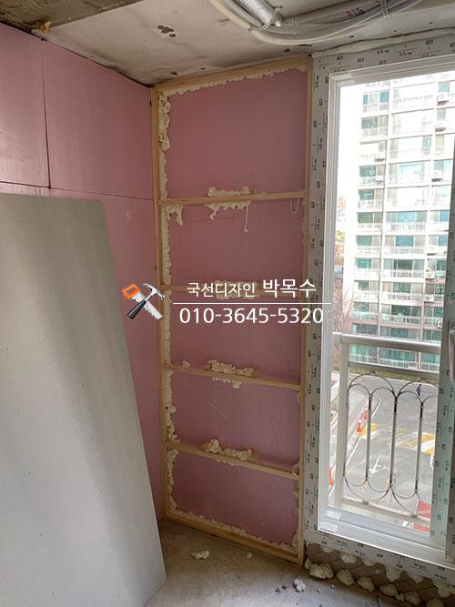 핑크색 단열 보드와 목재 프레임이 설치된 벽면