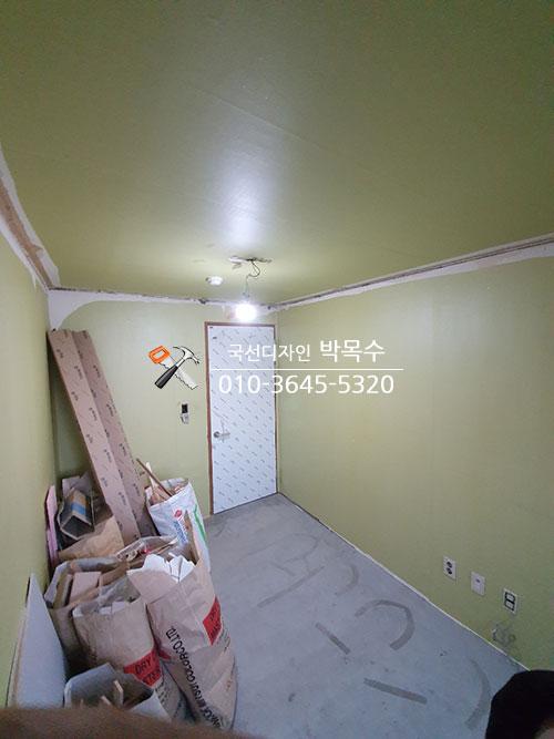 녹색 페인트 벽면과 자재들이 놓인 실내