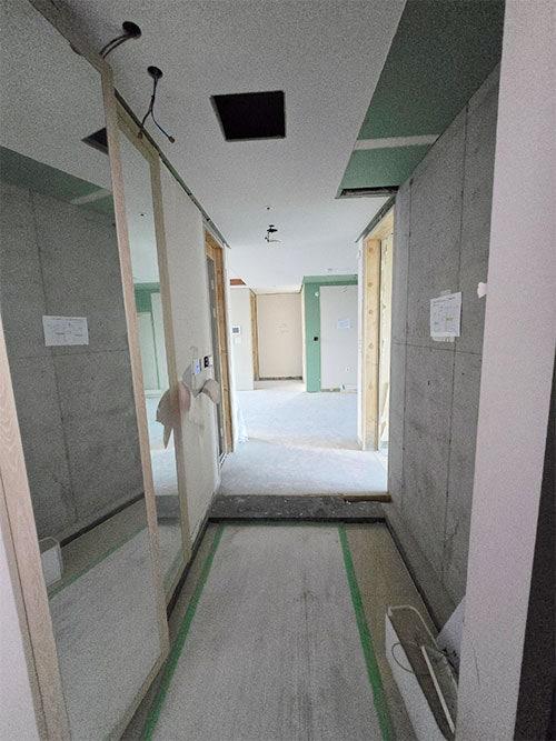 콘크리트 벽면과 노출된 전선이 보이는 복도 공사 현장