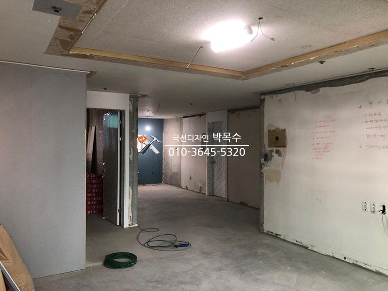 천장 목재 보드와 조명이 설치 중인 복도