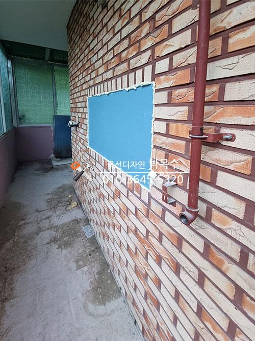 브릭 패턴 벽면과 파란색 보드가 부착된 발코니