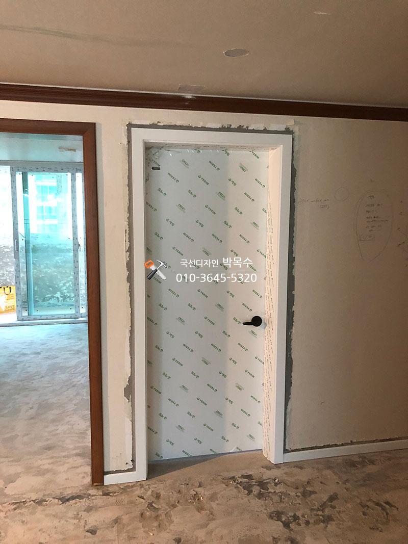 문틀 설치 후 보호 필름이 붙어 있는 벽면