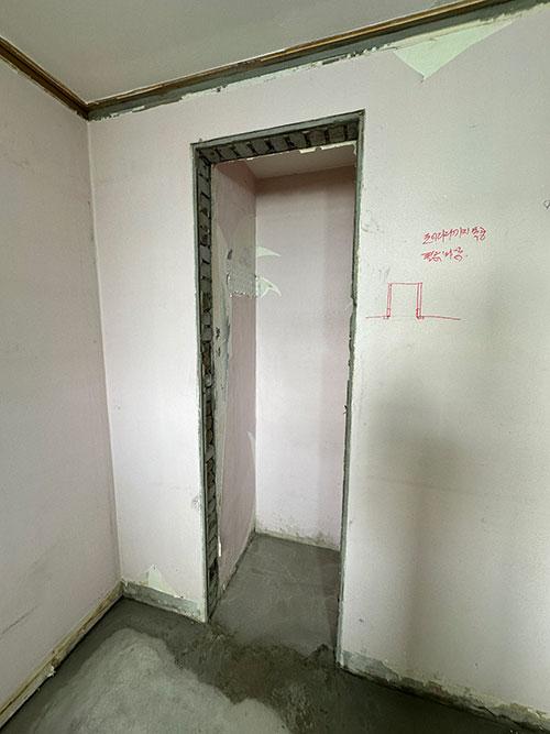 붉은 표시와 철거된 문틀이 보이는 복도