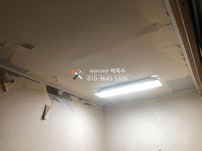 페인트가 벗겨진 천장과 중앙 형광등 조명