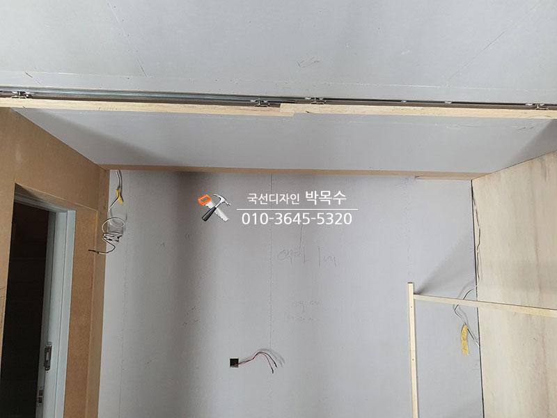 천장 레일 설치와 전선이 노출된 문 근처 공간