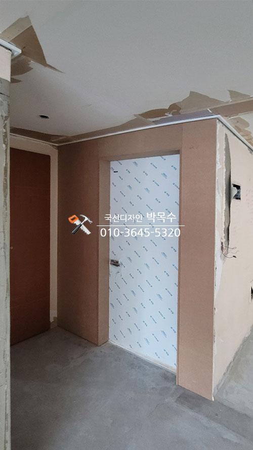 갈색 보드와 흰색 도배지가 섞인 복도 마감 전 모습