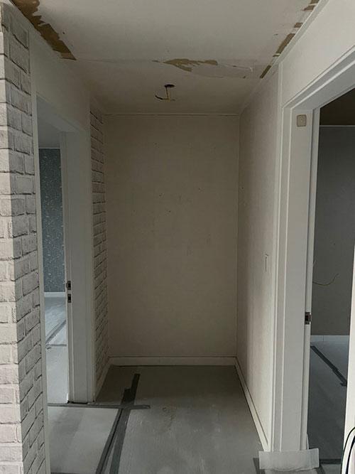천장 흠집과 벽면 페인트 마감이 진행 중인 복도