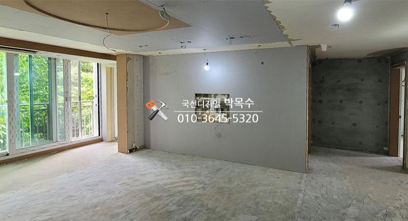 TV 매립 가벽과 천장 평탄화 작업이 진행 중인 공간