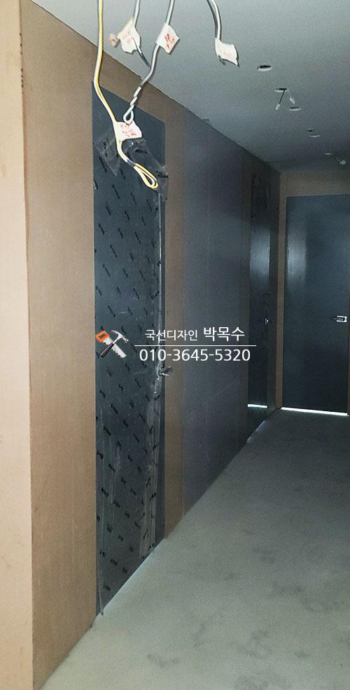 메쉬 보드가 부착된 복도 벽면과 노출 전선