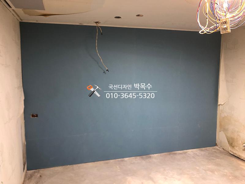 파란색 마감재가 보이고 전선이 노출된 벽면